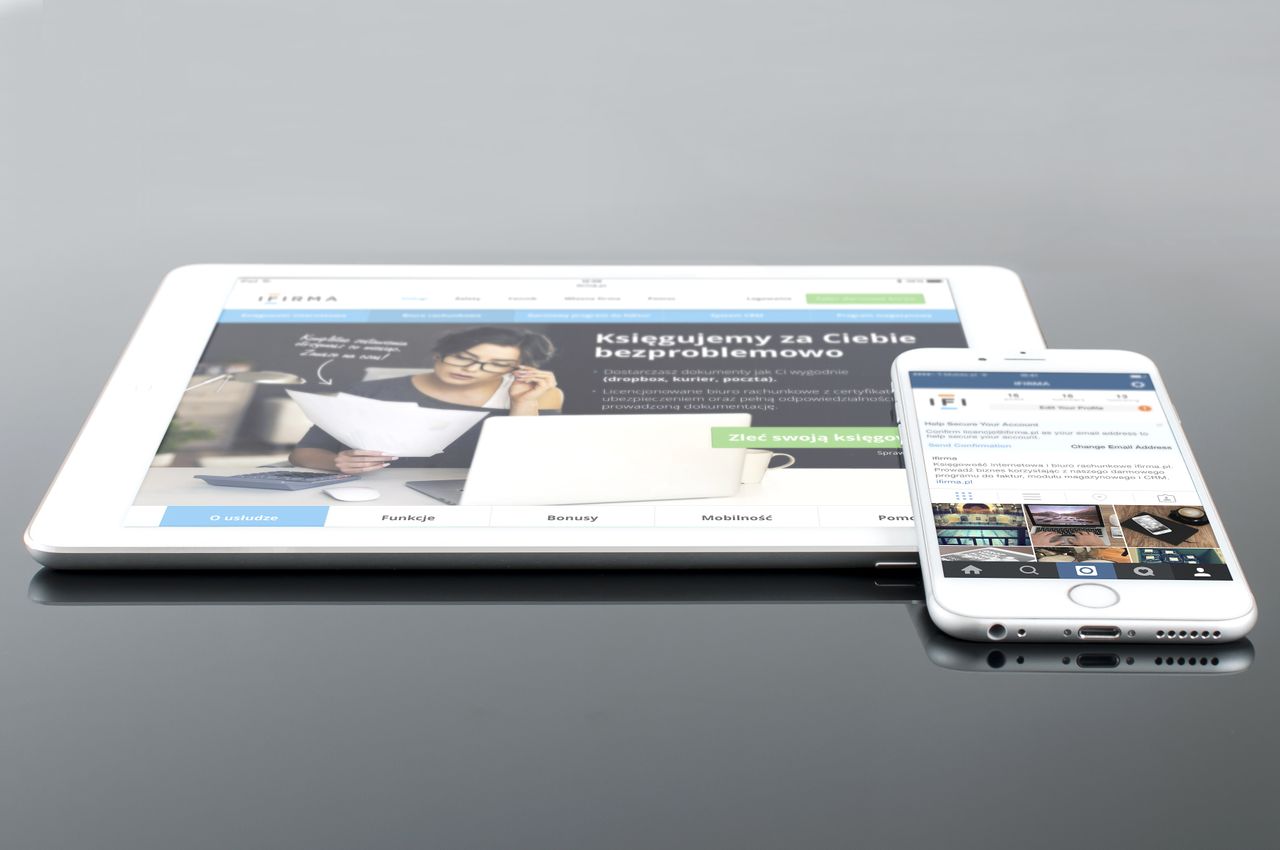 services-03 Tablette et smartphone modernes affichant du contenu web sur une surface réfléchissante, mettant en valeur la technologie et la connectivité.